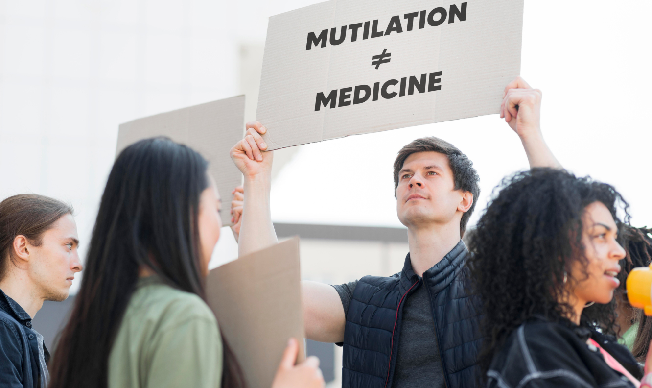 This image may represent a group of people participating in a protest, one of whom is holding up a sign that reads 'MUTILATION ≠ MEDICINE.'